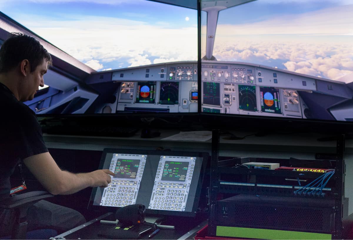 Jake Neighbors, software engineer, points to a simulated flight management system computer in Embry‑Riddle’s CARS lab, part of the virtual aircraft architecture being developed by CARS for the FAA to enhance aviation cybersecurity. (Photo: Embry‑Riddle/Jayson Clifford)