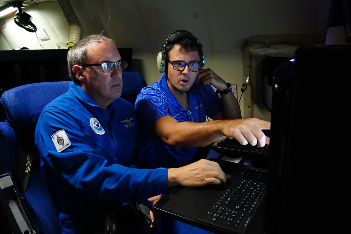 Embry‑Riddle meteorologist Dr. Josh Wadler (right) aboard a hurricane hunter aircraft, where he deploys drone technology to probe atmospheric conditions inside hurricanes. (Photo: CBS News/Jake Barlow)