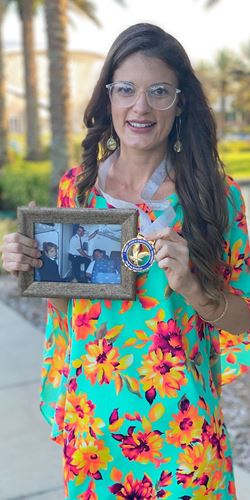 Marisa Aguiar shows her Ph.D. medal while holding a picture of her father (middle, standing), one of the pilots who died in the crash of American Eagle Flight 4184 in 1994. (Photo: Marisa Aguiar)