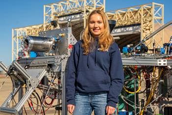 AJ Giza, the project lead for Triton, stands near the rocket engine before its hot fire test. (Photo: Embry‑Riddle/Darren Nguyen) 