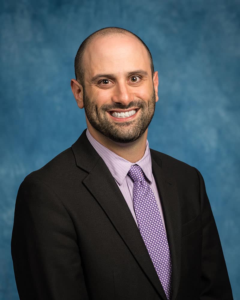 Portrait-style photo of Joseph Keebler in front of a blue background.