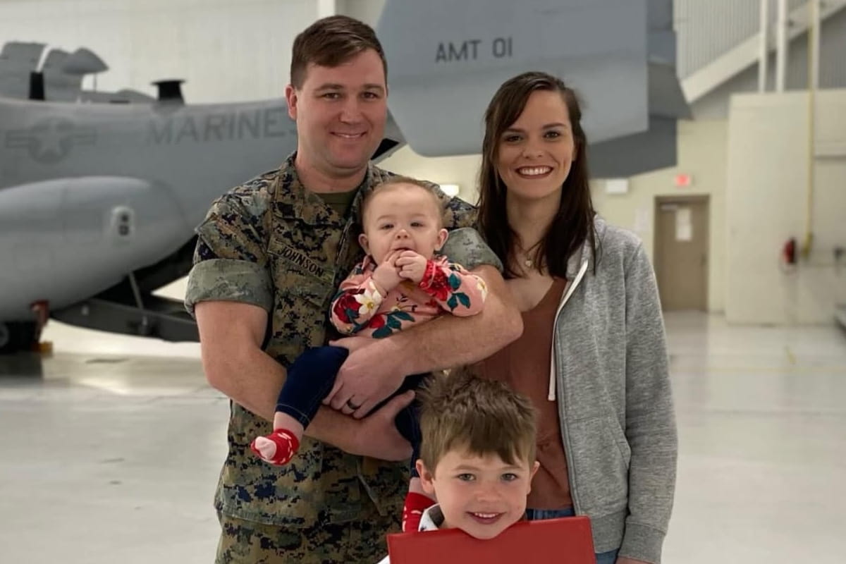 Taylor Johnson holds daughter Evelyn in front of a Marine Corps V-22 Osprey with his wife Rachel and son Daniel.
