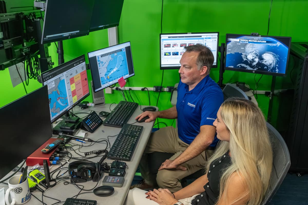 Dr. Rob Eicher and alumna Madison Croker review hurricane forecast graphics in Embry-Riddle’s Weather Broadcast Studio.