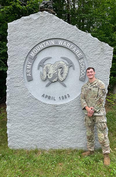 Cadet Hunter Williams stands next to monument.