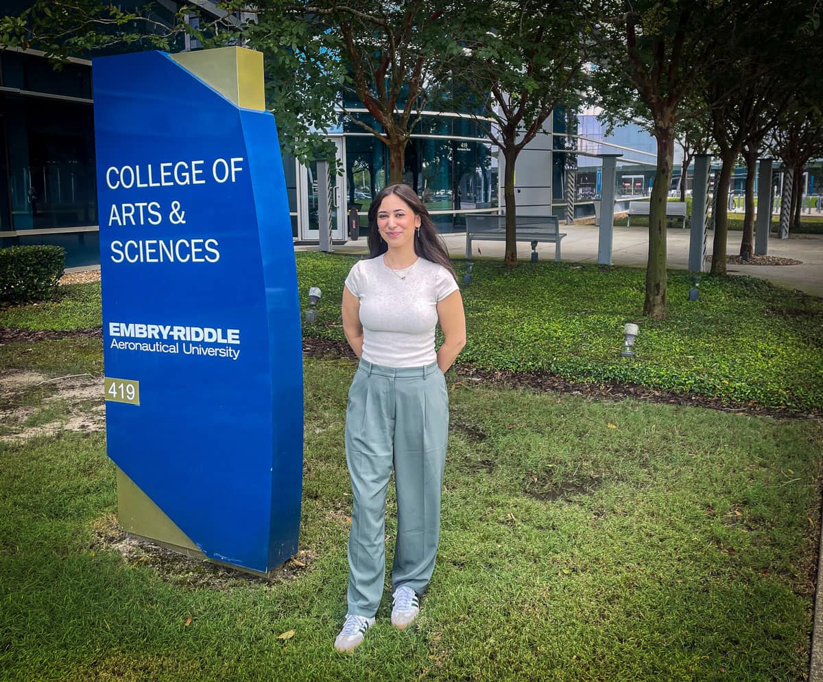 Embry-Riddle Ph.D. graduate Jenna Korentsides in front of the College of Arts & Sciences