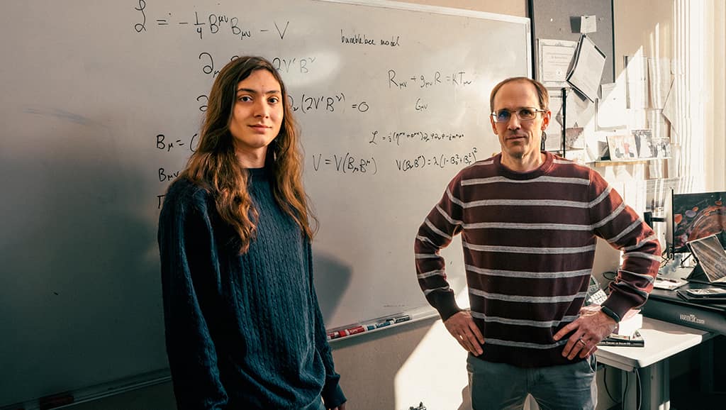 Space Physics undergraduate Dario Walter-Cardona and Dr. Quentin Bailey standing in front of white board.