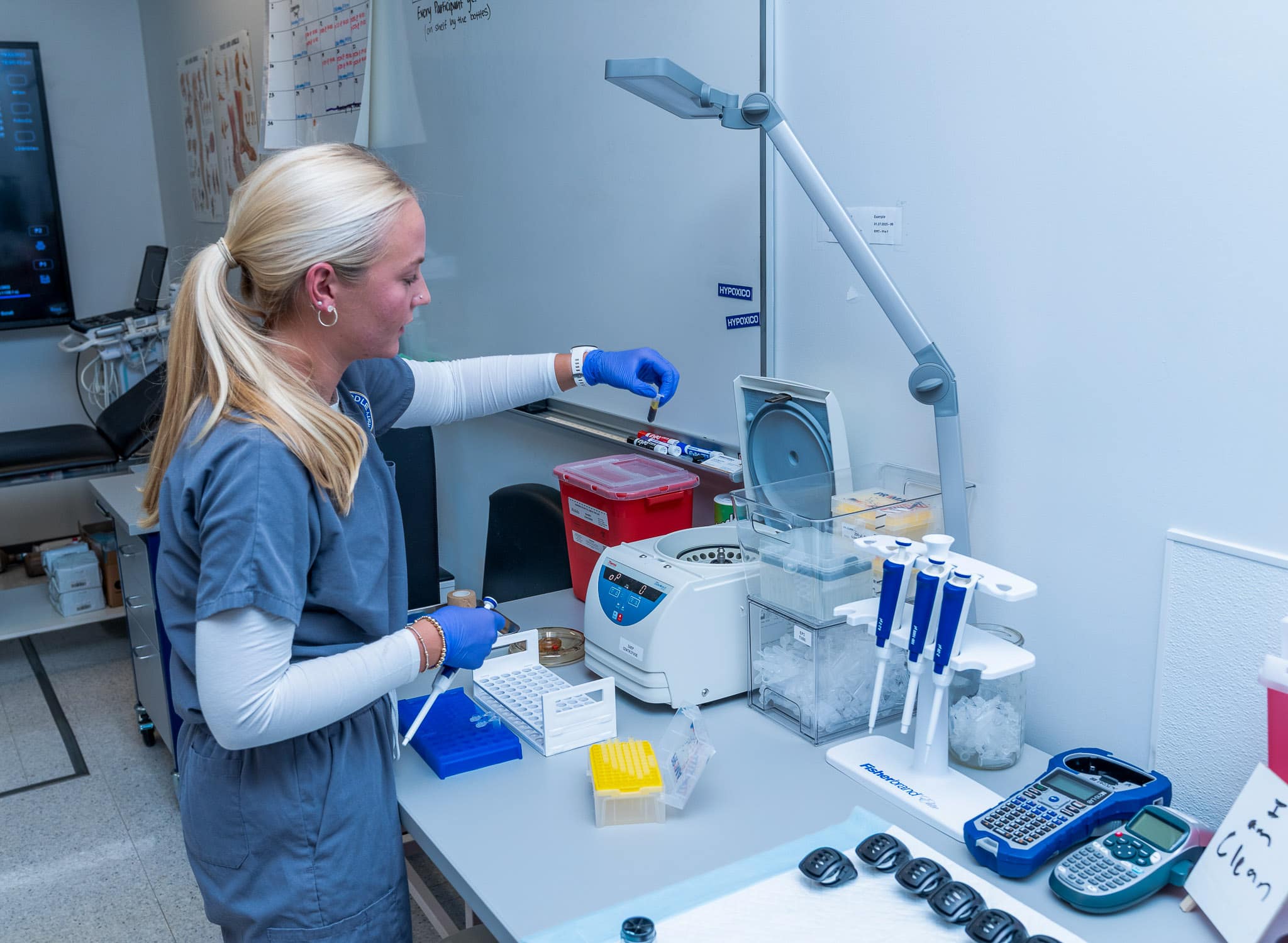 Erica Bryant, a senior in Aerospace Physiology, removes a blood sample from the centrifuge.