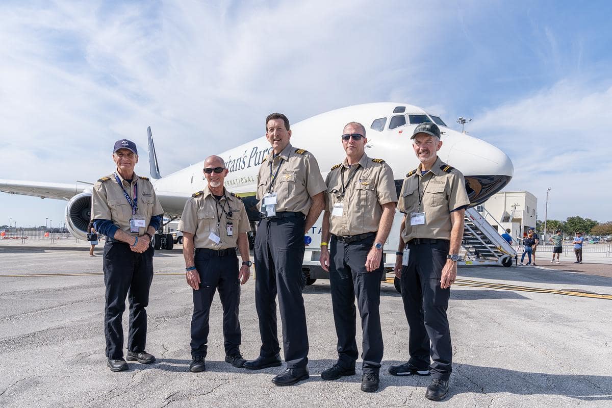 Embry-Riddle alumni crew members standing in front of plane.