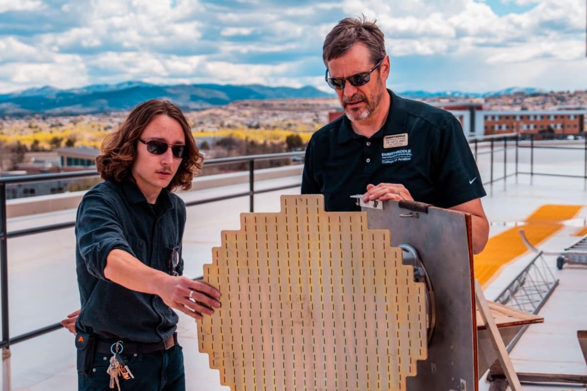 Embry‑Riddle student assistant Sawyer Curless (left) and Dr. Curtis James, professor of Meteorology, install the Honeywell IntuVue RDR-7000 antenna array atop the Academic Complex building at the Prescott Campus.