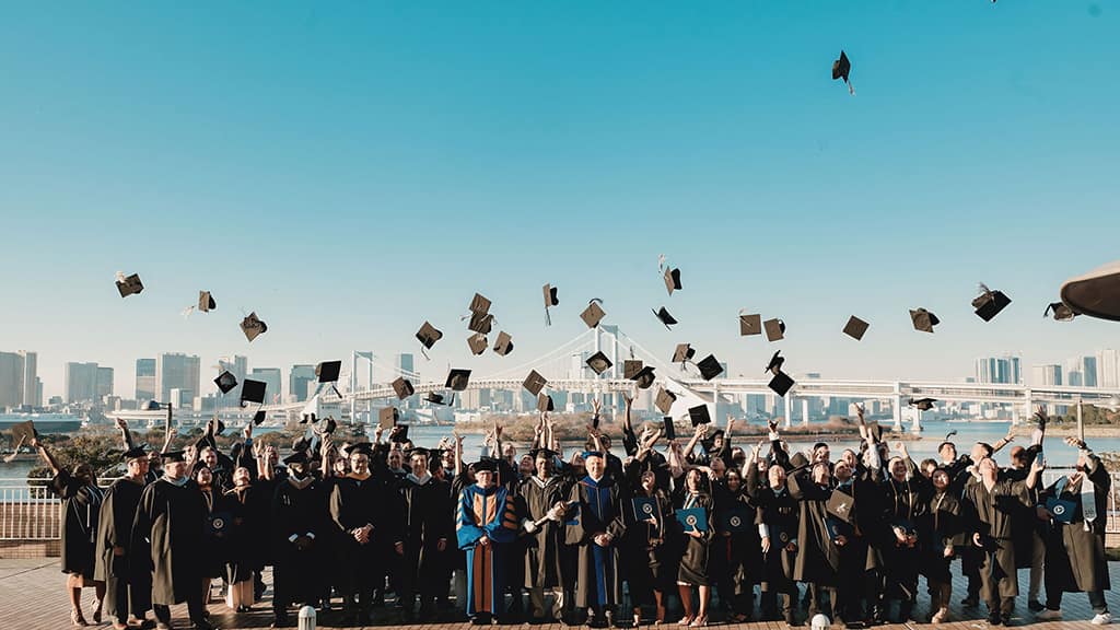Graduates throw hats in the air.