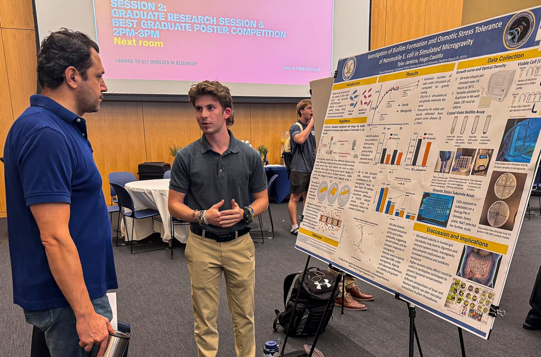 Tyler Jenkins, a sophomore Aerospace Physiology student, talks to an attendee about his research.