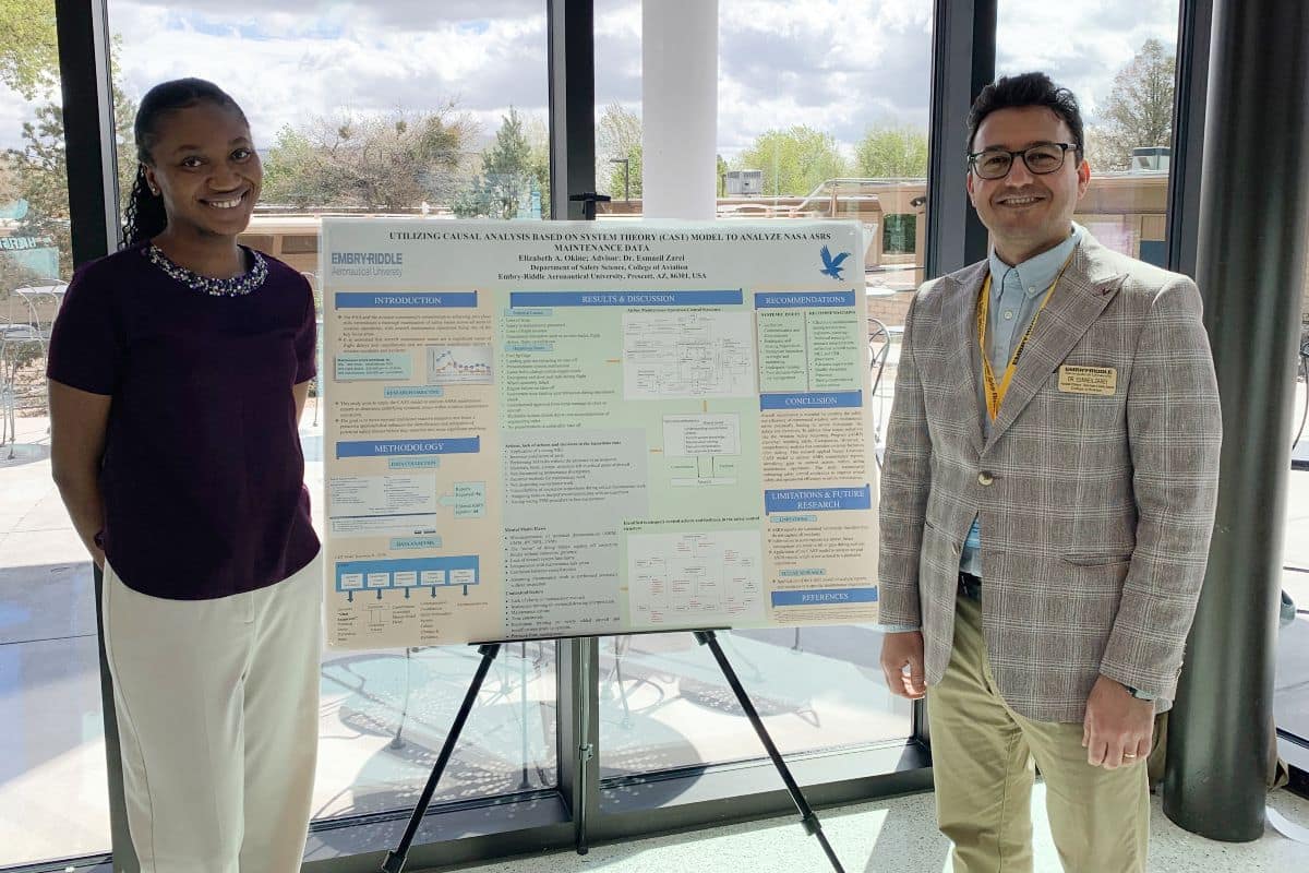 Elizabeth Okine and Dr. Esmaeil Zarei display research on chart.