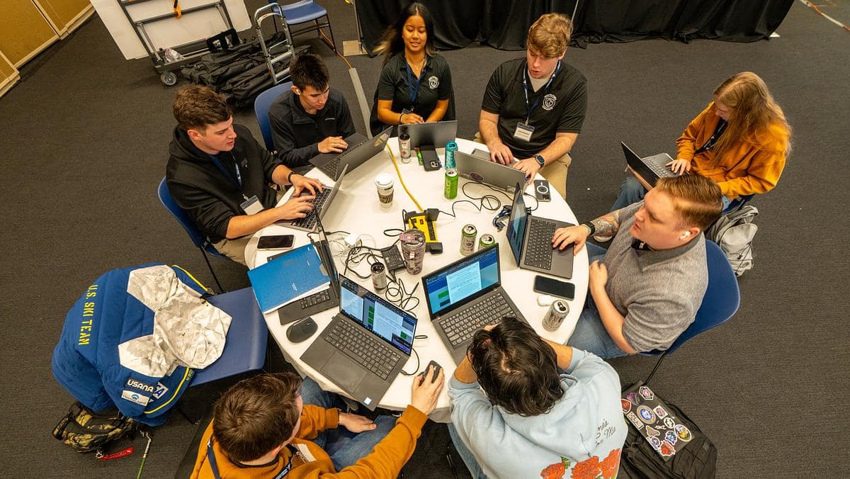 Embry-Riddle students work around a table during a cyber competition.