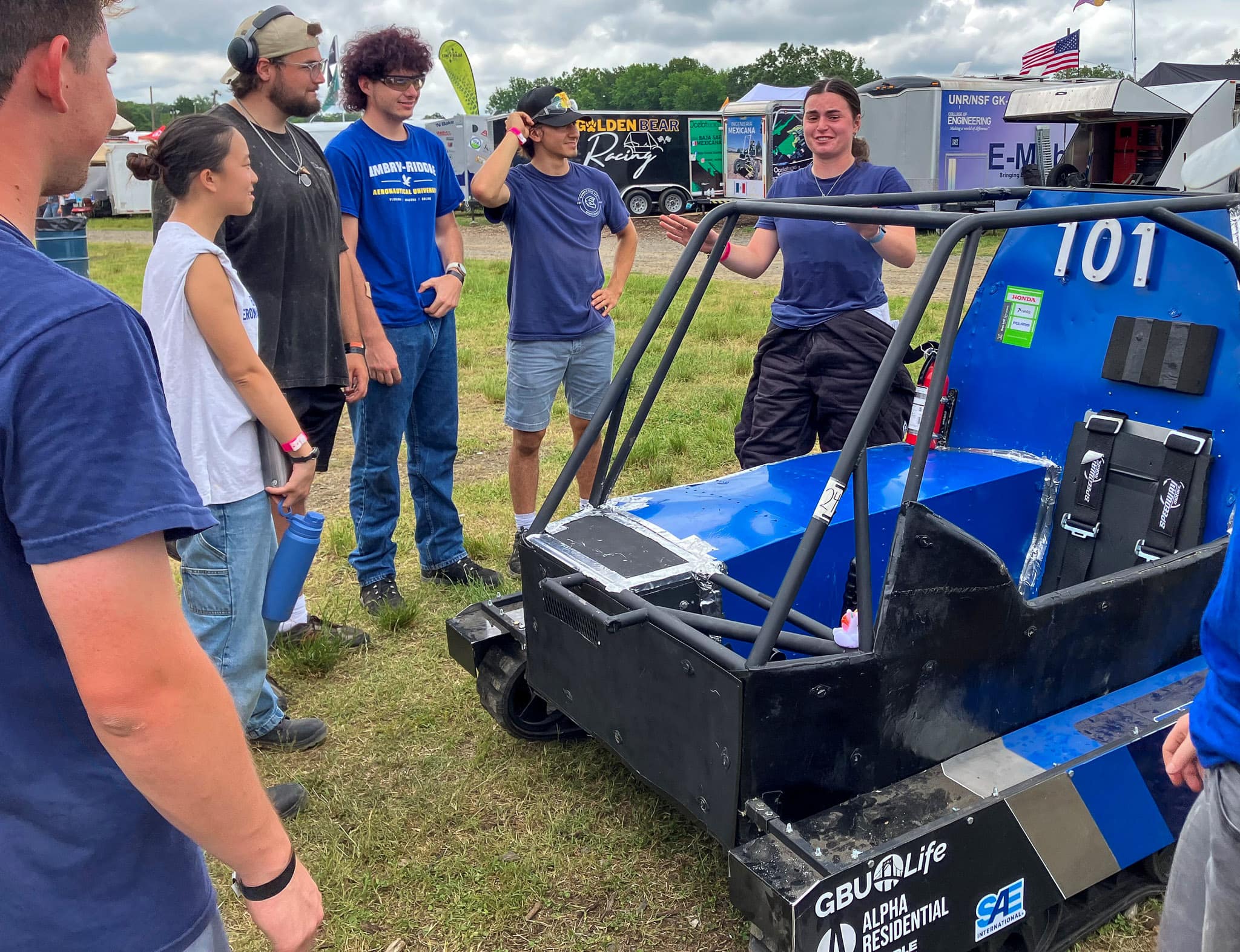 Woman talks to teammates at Baja SAE competition.