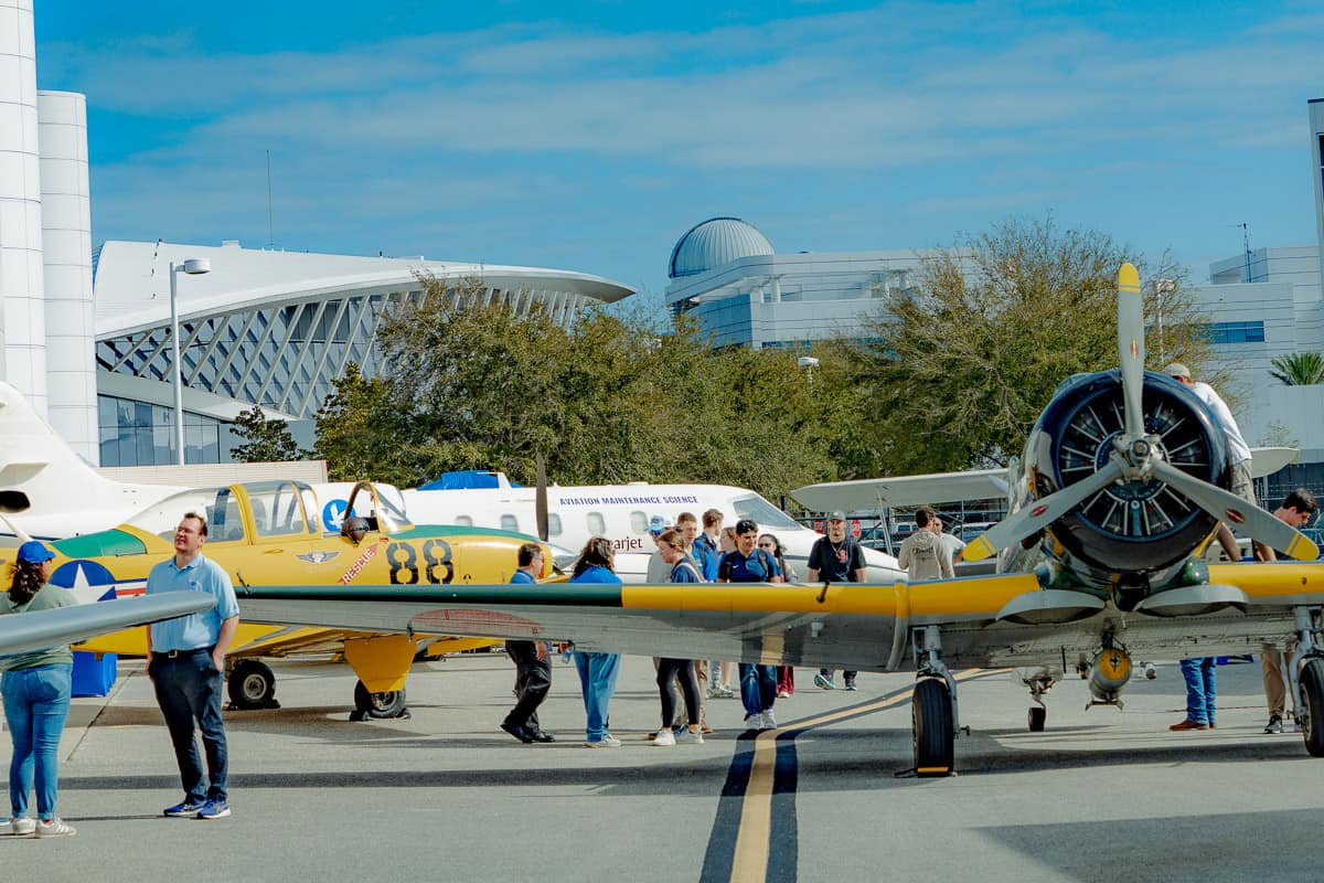 Students, faculty, staff and other aviation enthusiasts tour a lineup of historical planes.