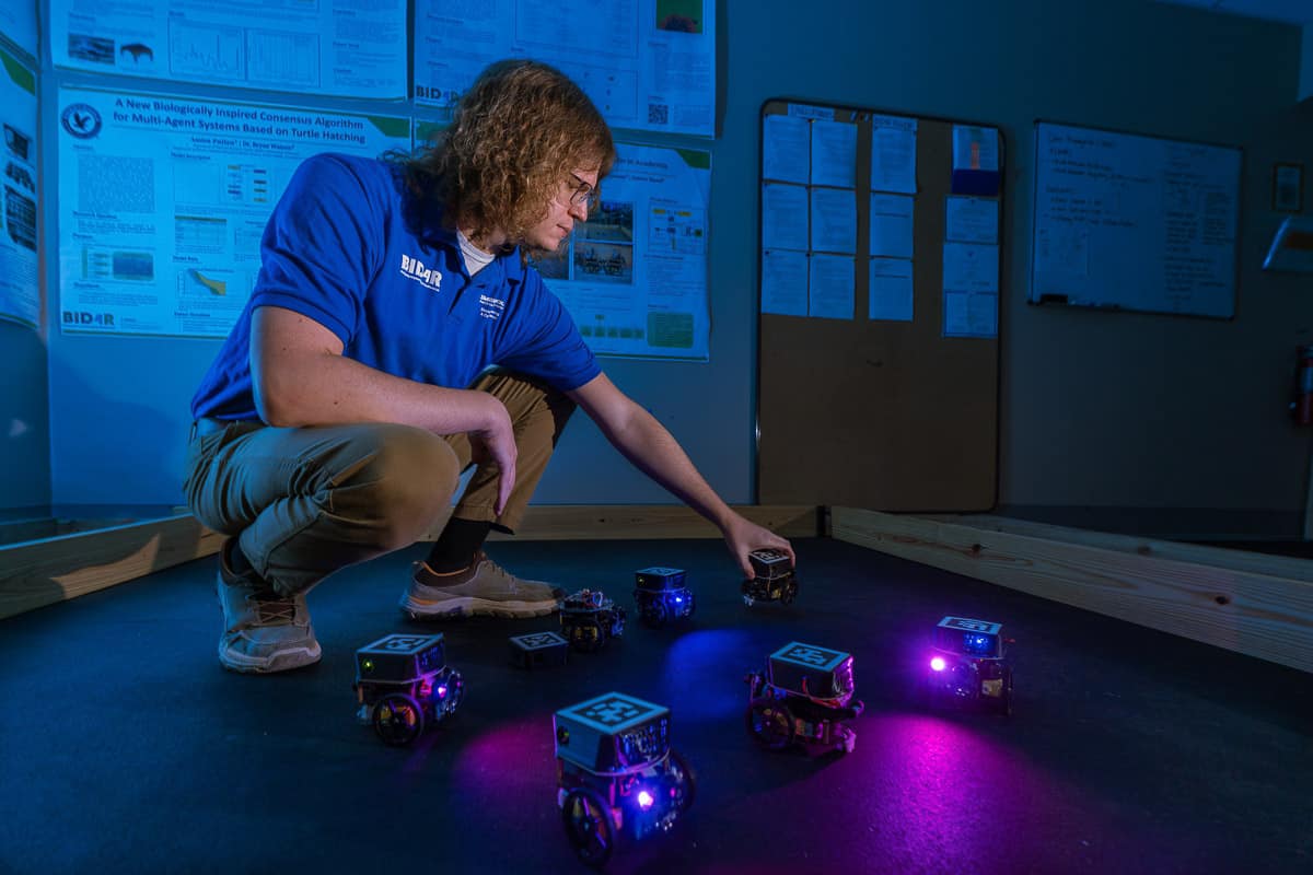 James Hand working with robots in an Embry-Riddle lab.