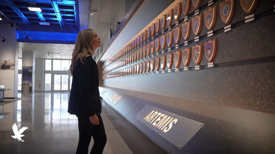 Alora Mazarakis looks at plaques on wall.