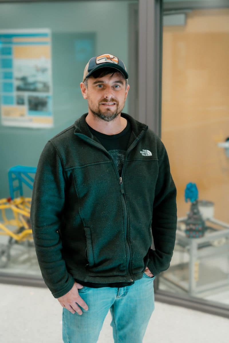 Ryan Parsons stands in a classroom.