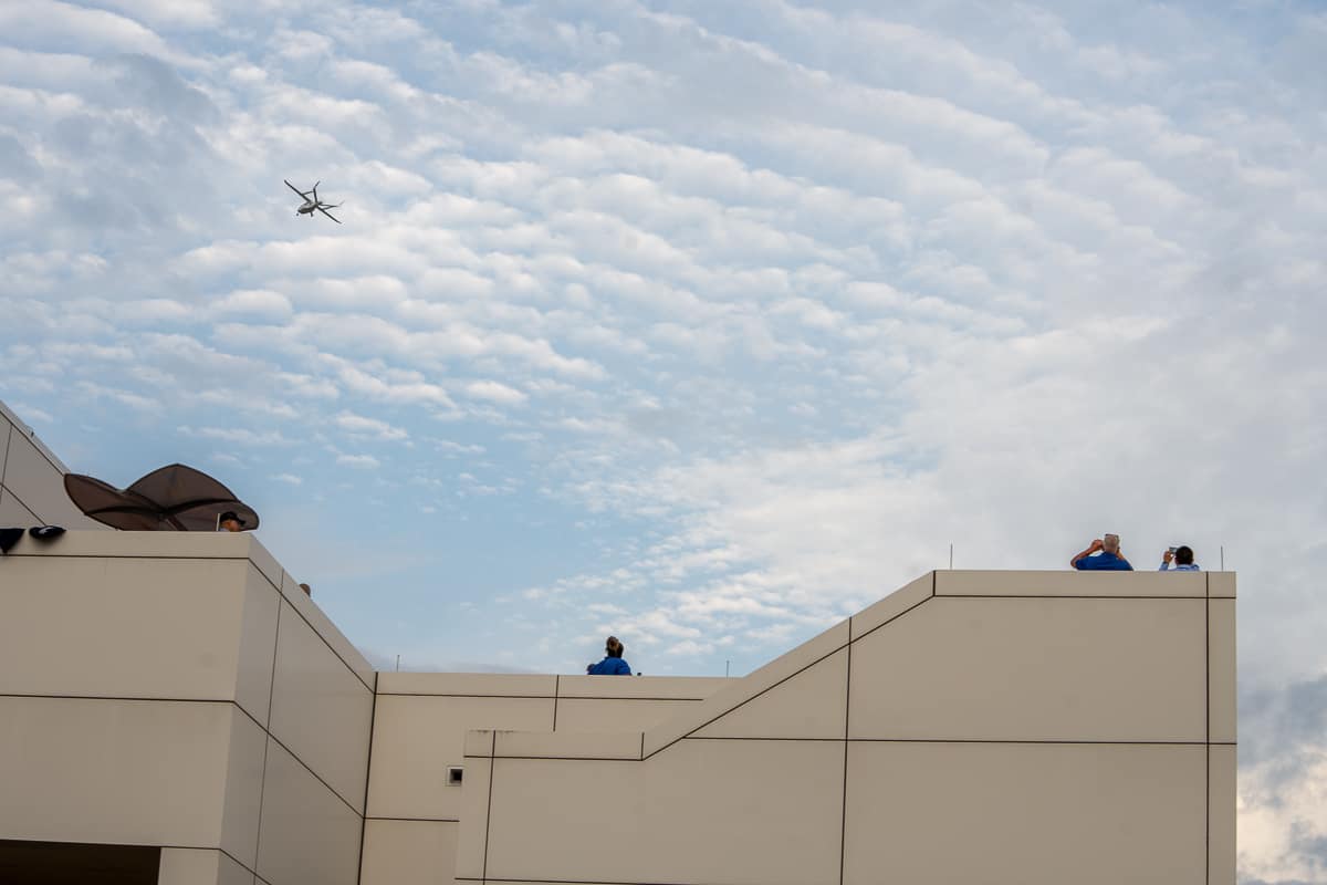 Electric fixed-wing airplane flying in blue sky.