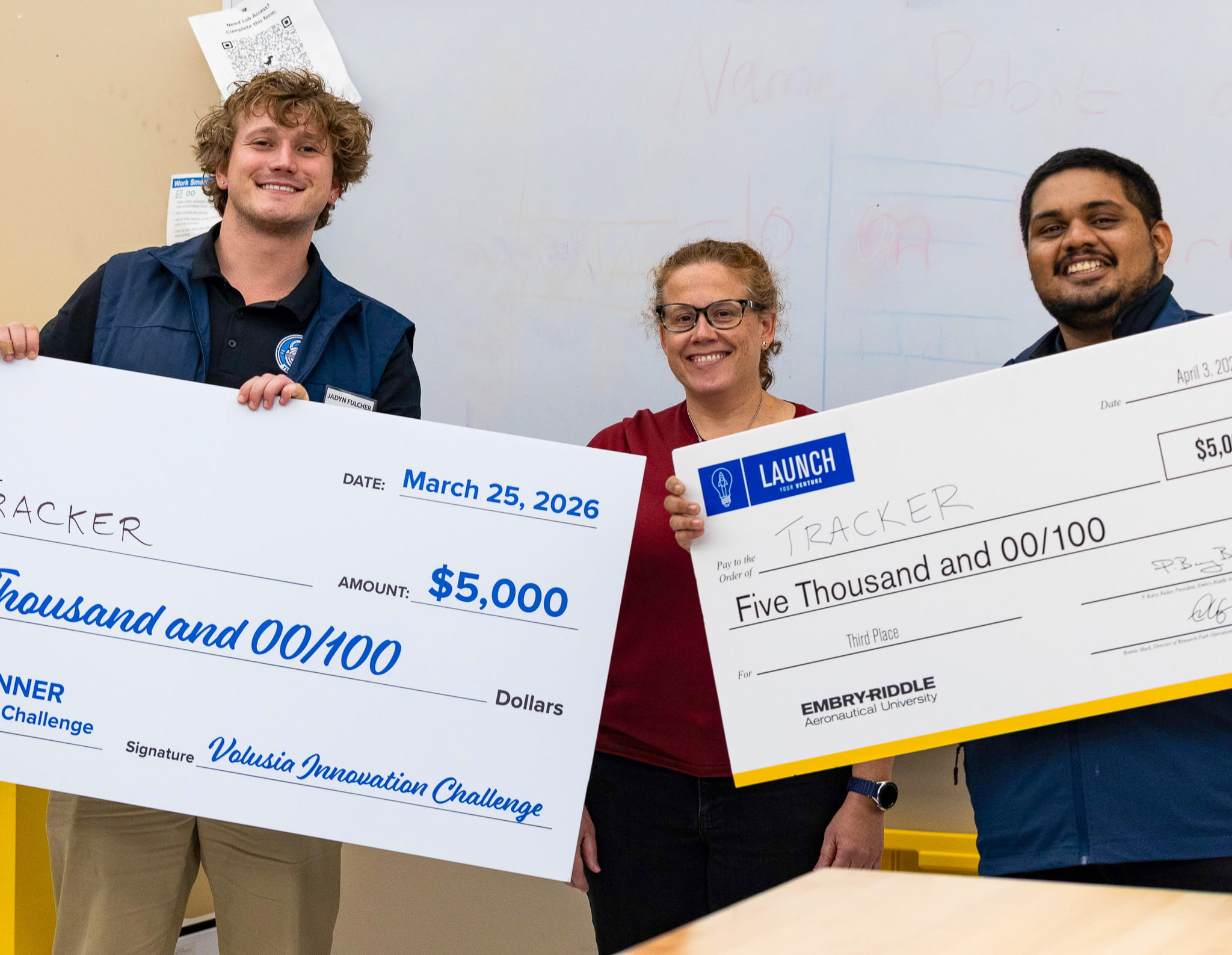 Students and faculty holding large donation checks.