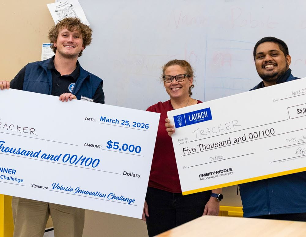 Students and faculty holding large donation checks.