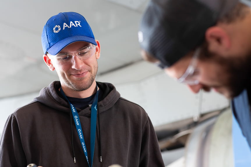 Man in AAR Corp hat along with a colleague