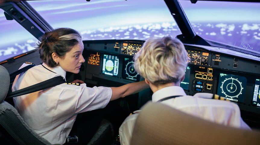 A woman in the flight deck of a plane simulator