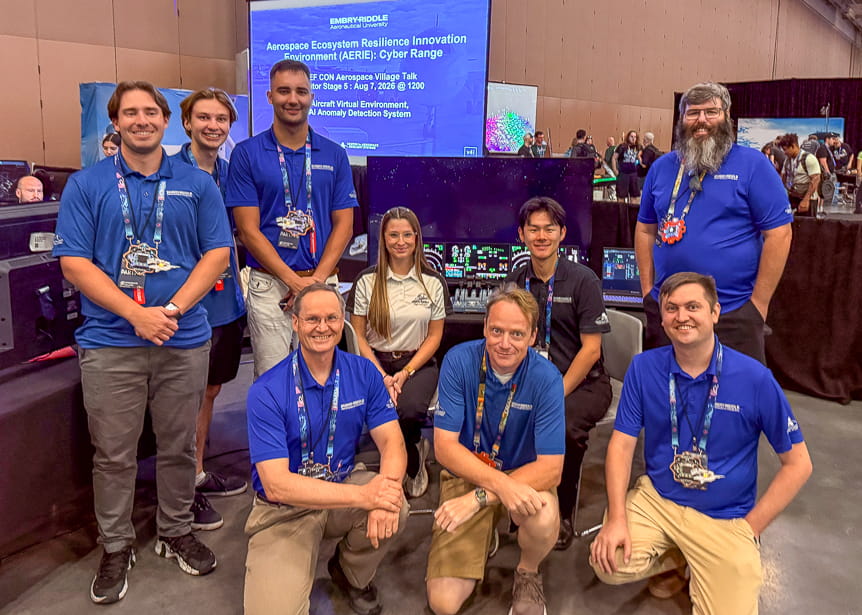 12 people in a row in front of screen at the DEF CON conference