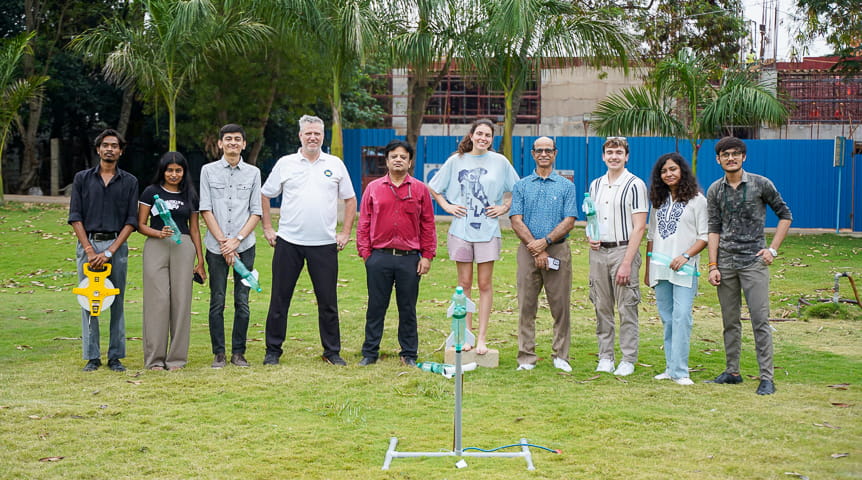 Students stand before a water-jet propulsion system they created