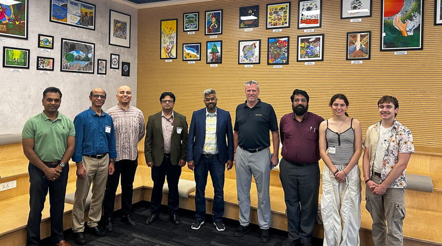 Students and faculty stand in a room at Alliance University in India 