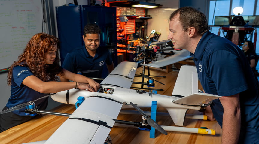 Two female students and one male student work on an uncrewed aircraft system