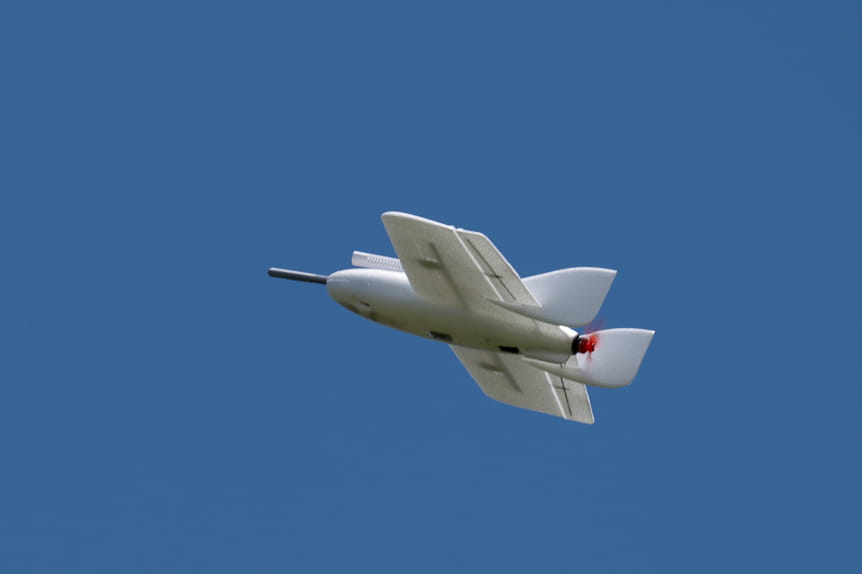 Small propeller aircraft flying against a clear blue sky during daytime.