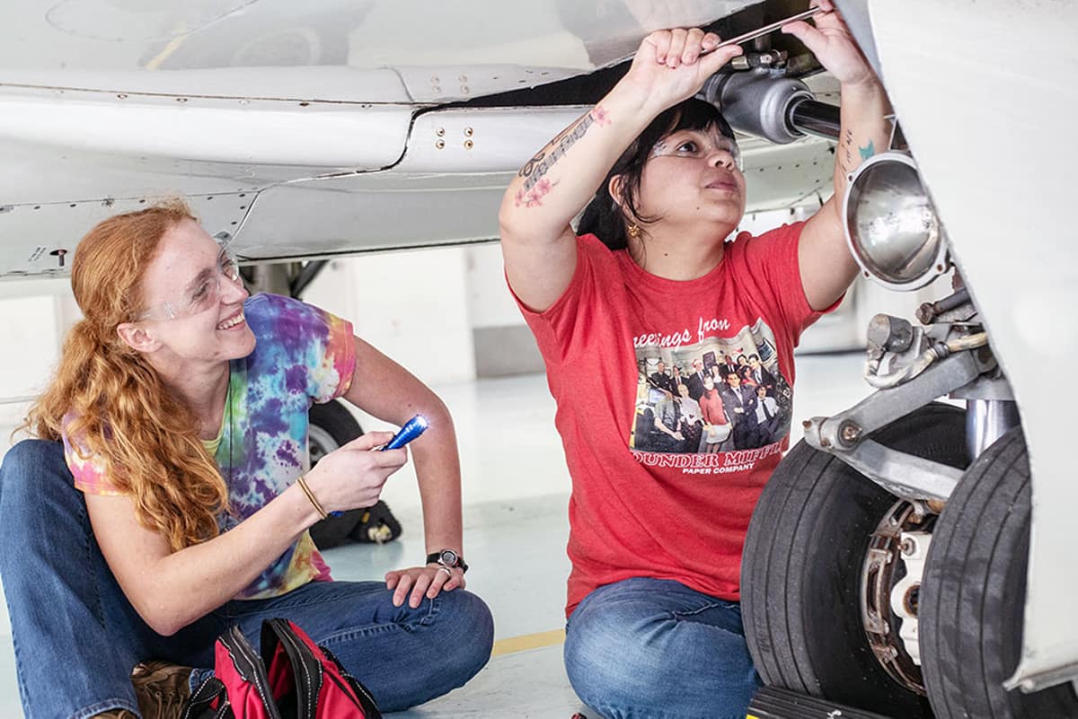 Female students fix a plane