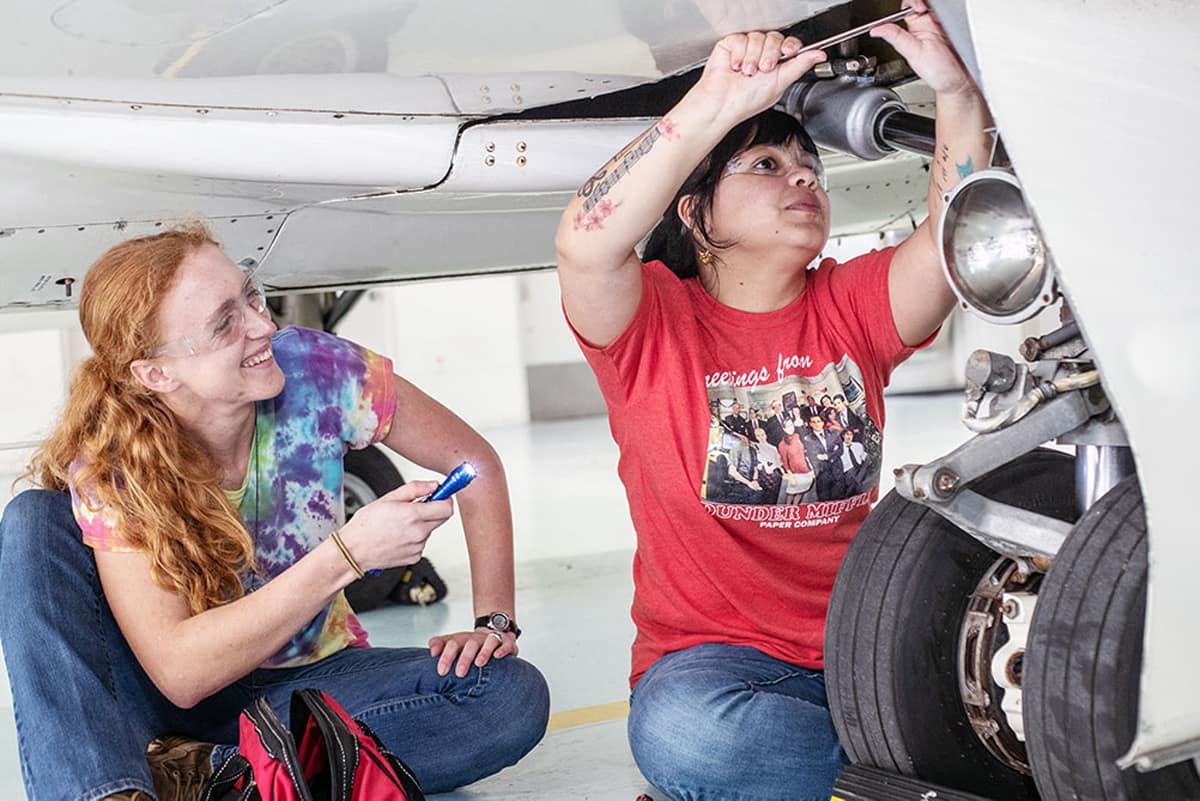 Female students fix a plane