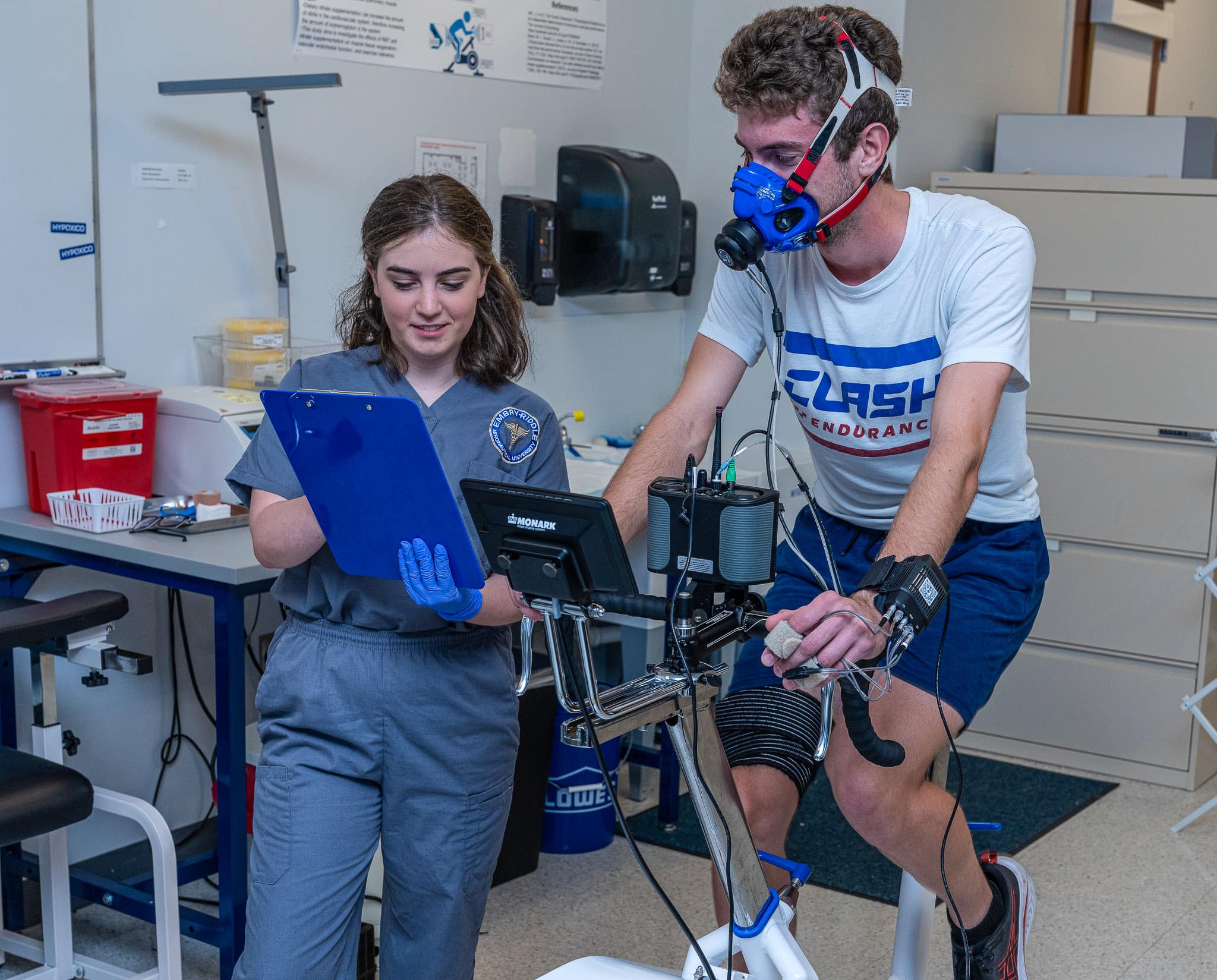 Riley Dienna, an Embry-Riddle senior studying Aerospace Physiology, measures a participant’s rating of perceived exertion, an indication of exercise intensity, during a maximal oxygen uptake test.