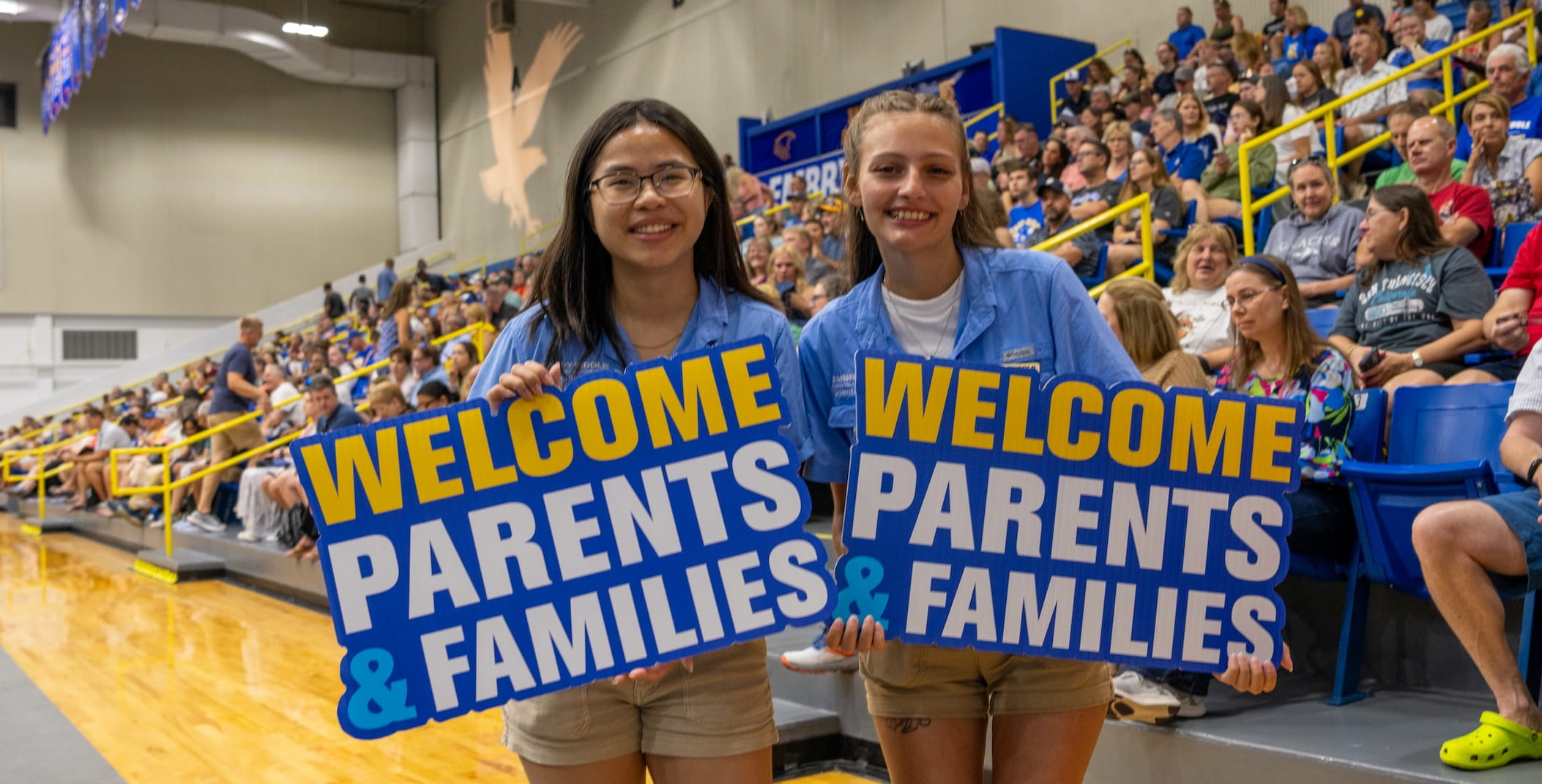 Two students holding signs at a pep rally