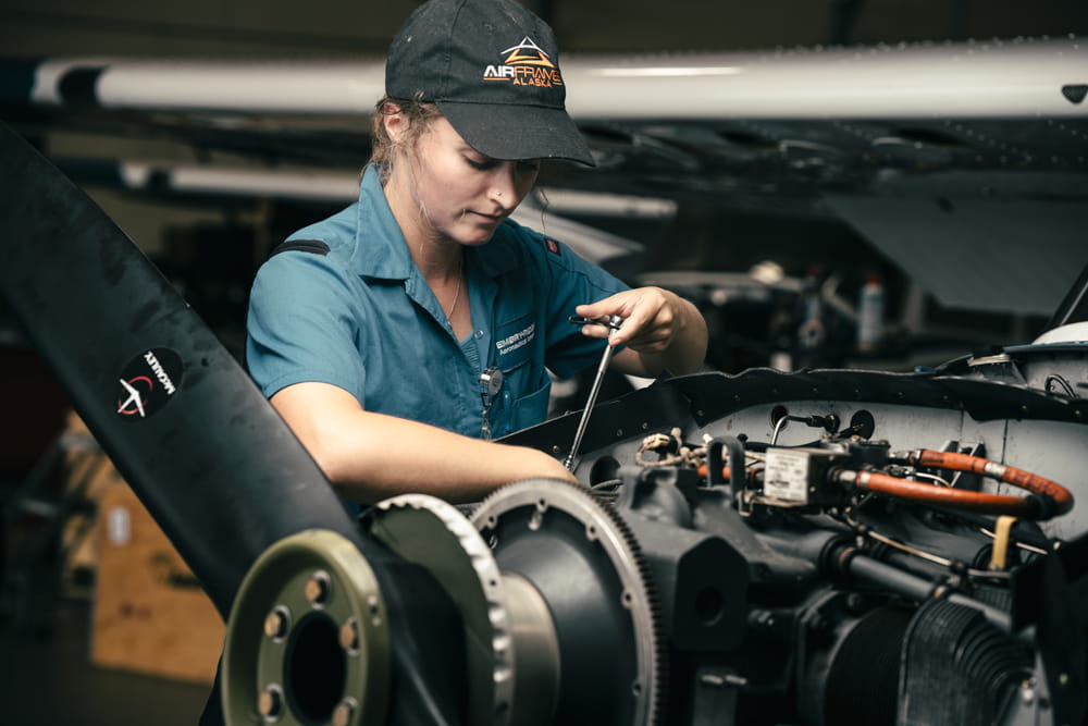 An Embry-Riddle student performs maintenace on parts of a plane in the Aircraft Fleet Maintanance hangar