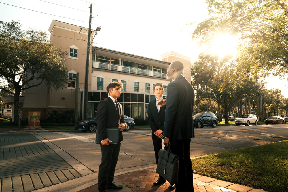 Embry-Riddle business students gather on a sidewalk downtown