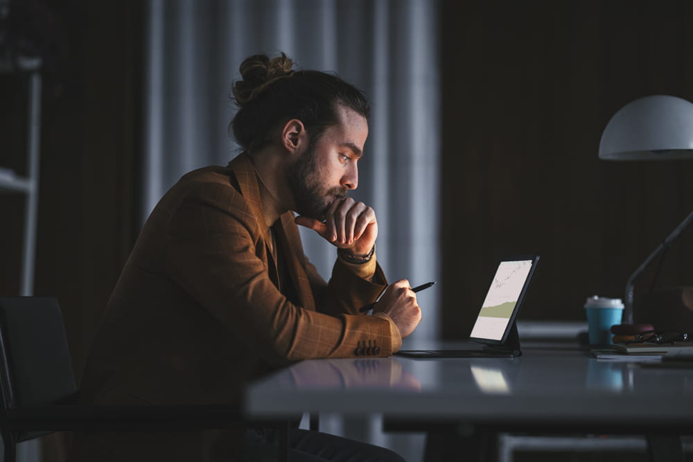 a man uses a tablet in a dark room
