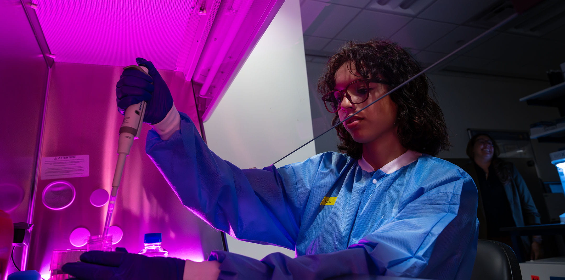 Embry-Riddle student uses a pipette to put a substance in a beaker