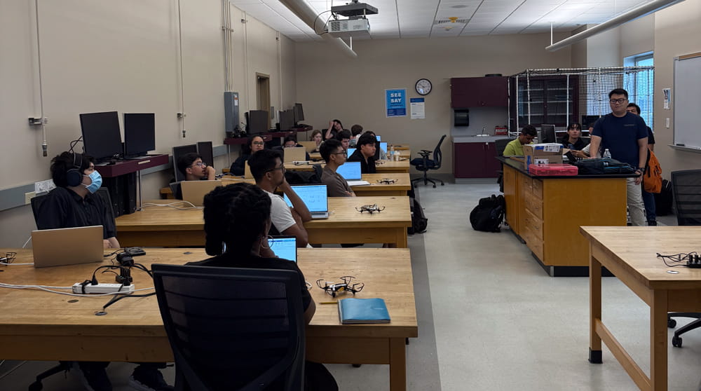Students listen to a professor in a lab