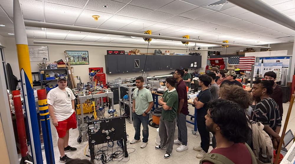 Students look at drones in a large lab