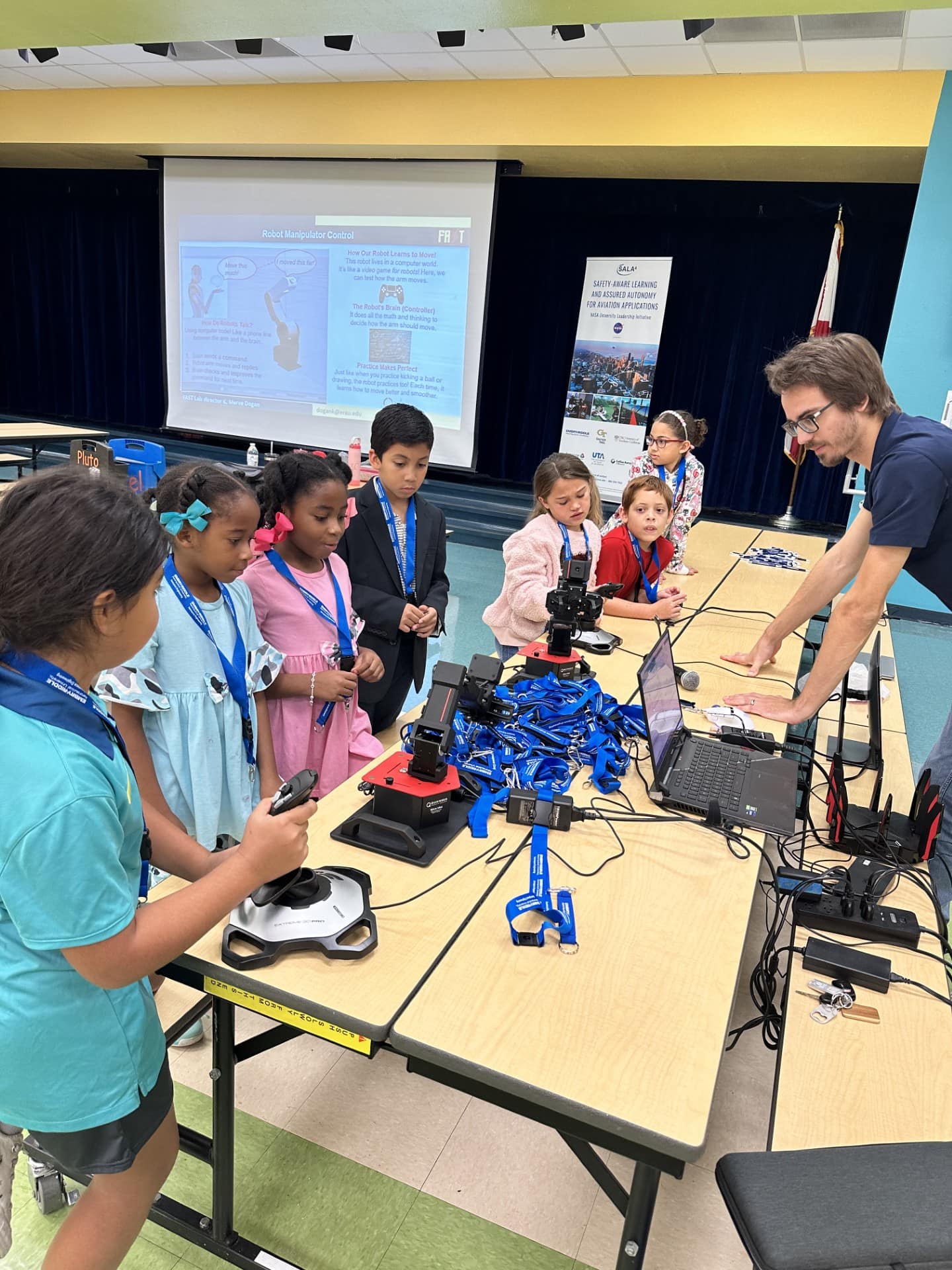Students play with controllers and a simulator during a STEM outreach
