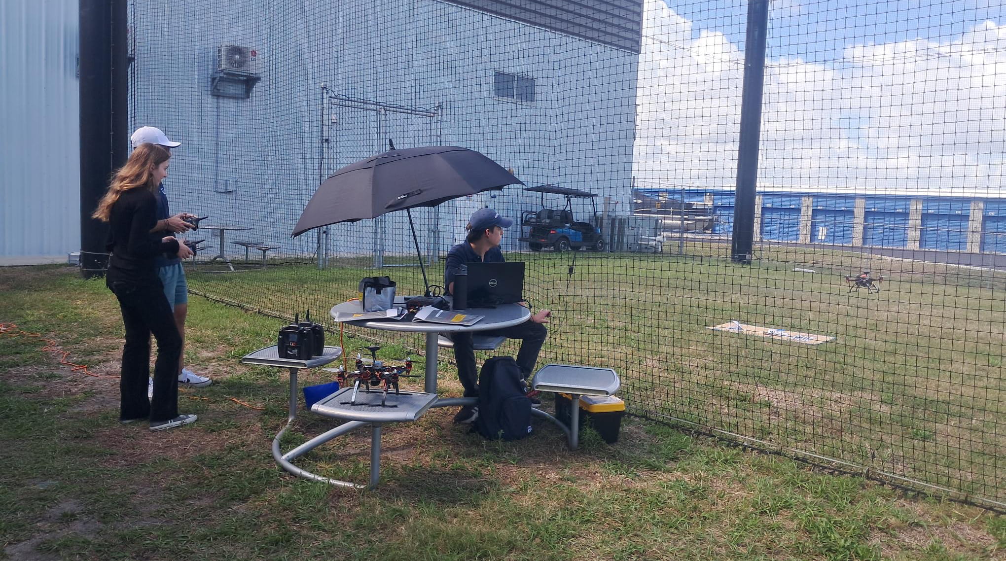 Students test drones in the enclosed drone net area.