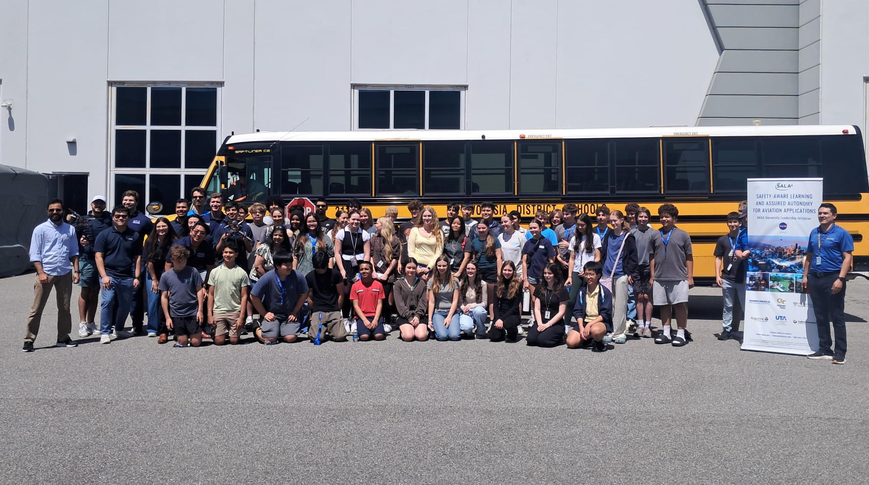 Group photo of the students, staff and faculty on STEM Day in front of the bus.