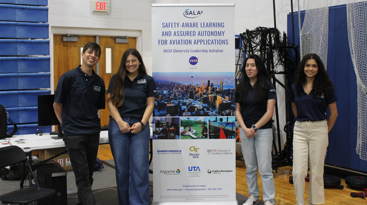 Embry-Riddle students pose next to a STEM sign
