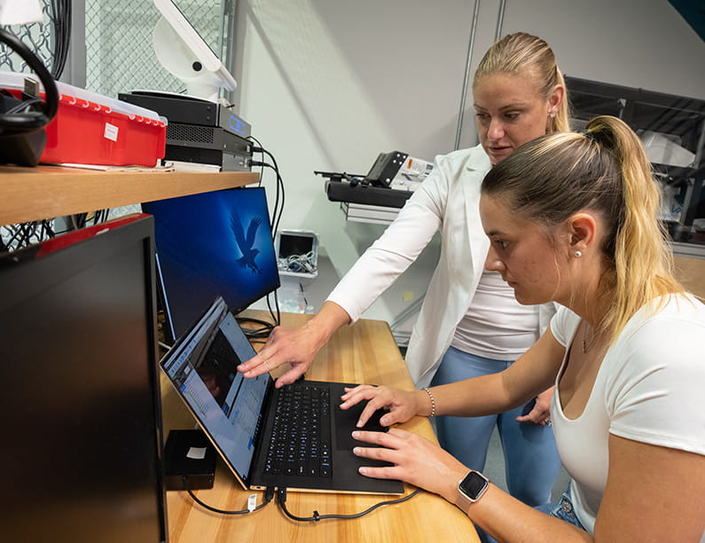 Dr. Christine Walck works with Paola Diaz Portela on research developing a parasports device to make kayaking accessible in the Micaplex at Embry-Riddle Aeronautical University