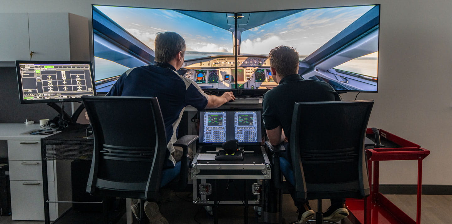 Students work on a flight simulator.