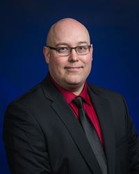 Ryan Wallace professional portrait with a blue background