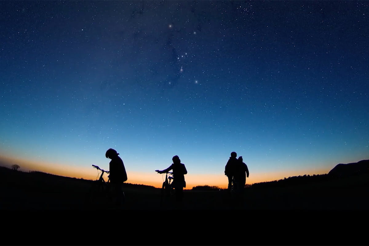 Kids on bicycles while the sun sets behind them